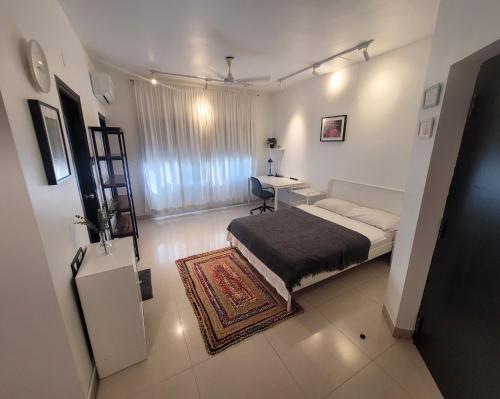 a bedroom with a bed and a desk in it at Lotus Korean Hotel in Bengaluru