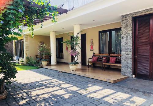 a courtyard of a house with benches and windows at Turtledove Guesthouse in Kuta