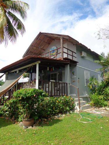 a house with a gambrel roof with a deck at Bungalow Ocean View wifi in Patillas