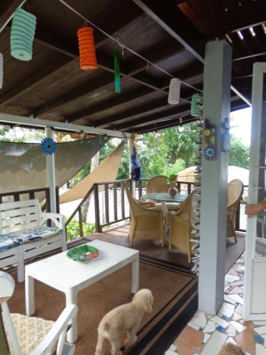 a dog sitting on a porch with a table and chairs at Bungalow Ocean View wifi in Patillas
