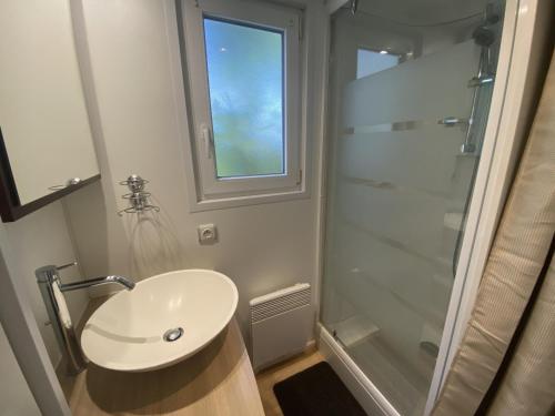 une salle de bain blanche avec un lavabo et une douche dans l'établissement Mobile Home tout confort 4 pers, proche plage et centre, clim, TV, terrasse, parking - FR-1-709-75, à Fouras