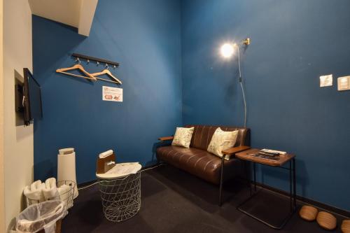 a living room with a couch and a blue wall at Apartment Sanjo in Nara