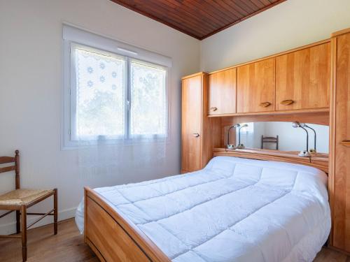 - une chambre avec un grand lit et des placards en bois dans l'établissement Maison 3 chambres proche plages avec jardin clos à Mimizan - pour 8 personnes - FR-1-50-127, à Mimizan
