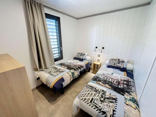 une chambre avec deux lits et une fenêtre dans l'établissement Chalet de Standing 6 Pers. à Jullouville - Piscine Chauffée, Plage à Proximité, Wi-Fi Inclus - FR-1-361-536, à Jullouville