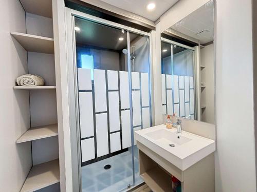 une salle de bain avec un lavabo et une douche dans l'établissement Chalet de Standing 6 Pers. à Jullouville - Piscine Chauffée, Plage à Proximité, Wi-Fi Inclus - FR-1-361-536, à Jullouville