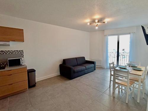 un salon avec un canapé et une table dans l'établissement Appartement T2 centre-ville, parking privé, animaux admis - FR-1-338-562, à Sète