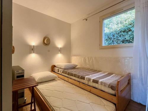 une chambre avec deux lits et une fenêtre dans l'établissement Appartement T2 Mezzanine, Piscine, Parking, Côte d'Azur - FR-1-226B-189, à Rayol-Canadel-sur-Mer