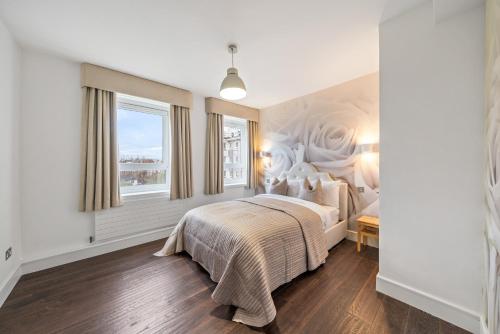 1 dormitorio con cama y ventana en Relax, Play and Work in London, en Londres