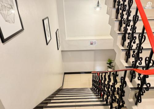 a staircase in a house with a red rail at Jacky Chan Hotel in Betong