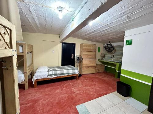 1 dormitorio con 1 cama en una habitación de color rojo en Hostal Pakal King, en Palenque