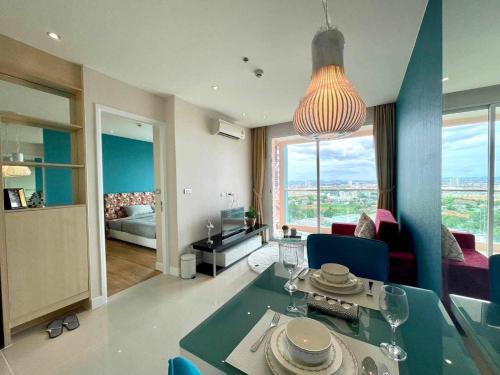 Grand Caribbean Condo Resort Pattaya 19 floor في جنوب باتايا: غرفة معيشة مع طاولة طعام وغرفة معيشة