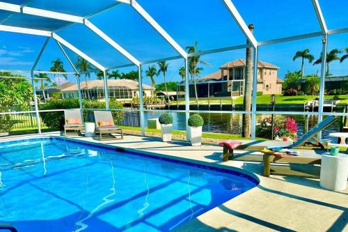 a swimming pool with a slide next to a house at Villa Palaco in Cape Coral