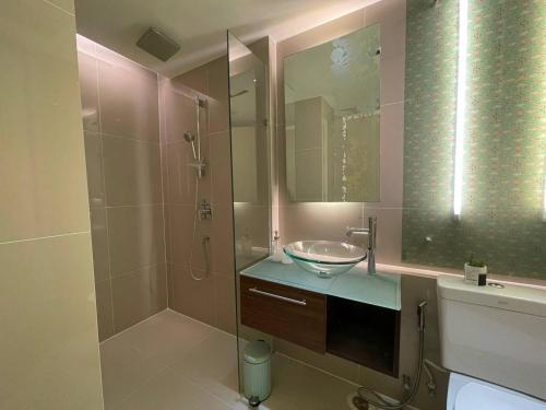 La salle de bains est pourvue d'un lavabo et d'une douche avec un miroir. dans l'établissement Grand Caribbean Condo Resort Pattaya 19 floor, à Pattaya (sud)