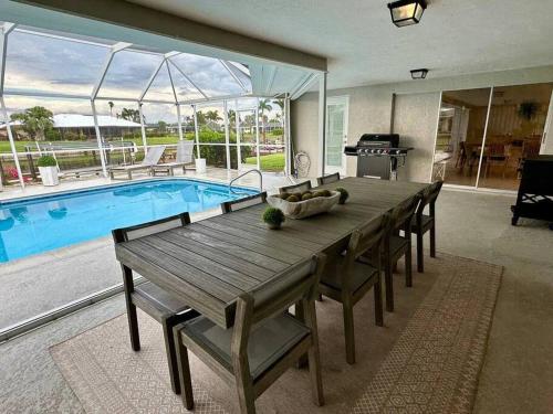 a dining room with a table and a swimming pool at Villa Palaco in Cape Coral
