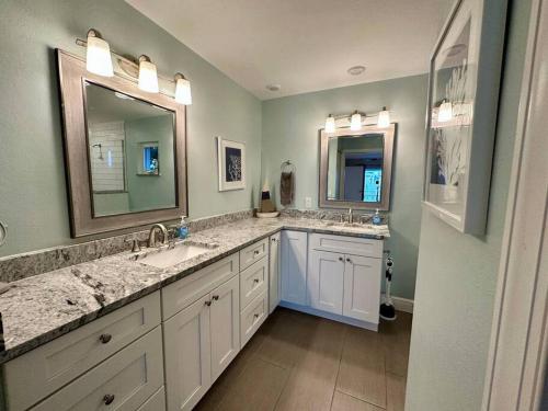 a bathroom with two sinks and two mirrors at Villa Palaco in Cape Coral