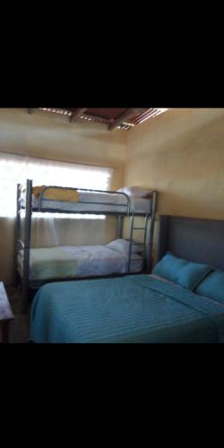 two bunk beds in a room with a window at CASA CERCA DEL MAR ZIHUATANEJO in El Coacoyul