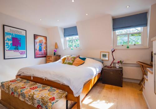 a bedroom with a large bed and two windows at Beautiful Mews House - Notting Hill (pbm) in London