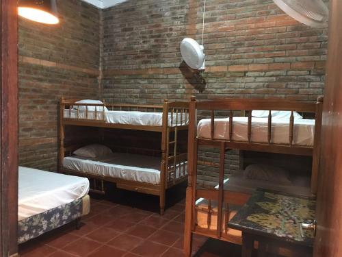a room with two bunk beds and a brick wall at Casa Vieja Surf Spa Mizata in La Libertad