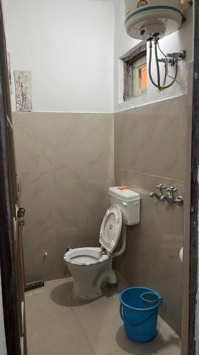 a bathroom with a toilet and a blue bucket at Occasions in Jammu
