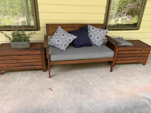 a bench with pillows on it next to two windows at Mountain Tranquility in Mount Tomah