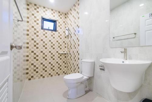 a white bathroom with a toilet and a sink at นาวาพูลวิลล่าหัวหิน VIP in Hua Hin