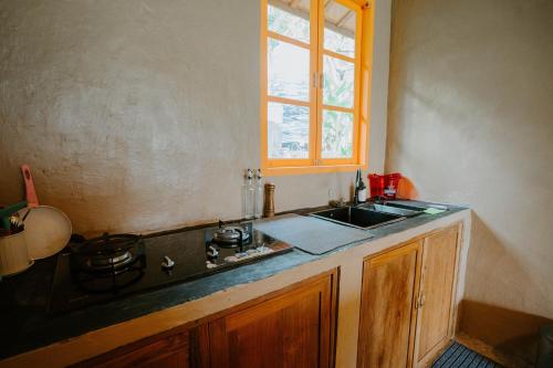 a kitchen with a sink and a stove and a window at Ravelyn House in Silebeng