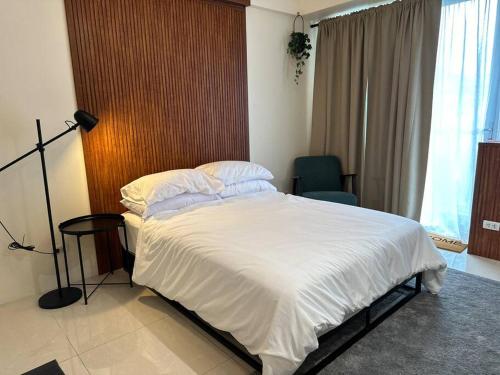 um quarto com uma cama grande e lençóis brancos em One Palm Tree villas with free parking em Manila