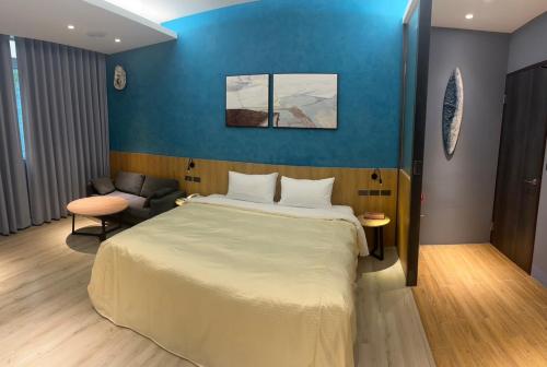 a bedroom with a large bed and a blue wall at 溫沙堡汽車旅館 Windsor Castle Garden Motel in Jiaoxi