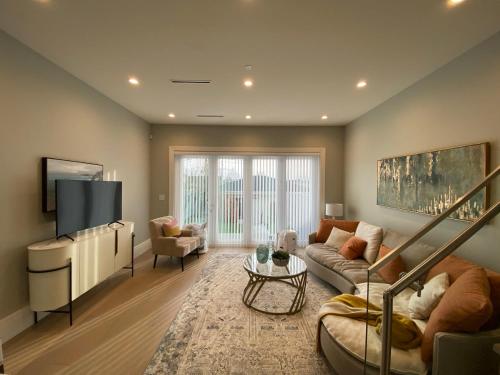 a living room with a couch and a tv at Four bedrooms New Lovely Duplex House-1628 in Vancouver