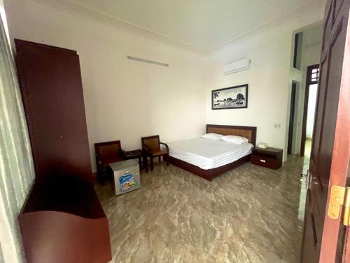 um quarto com uma cama, uma mesa e cadeiras em TRÀ MY HOTEL em Ðức Long