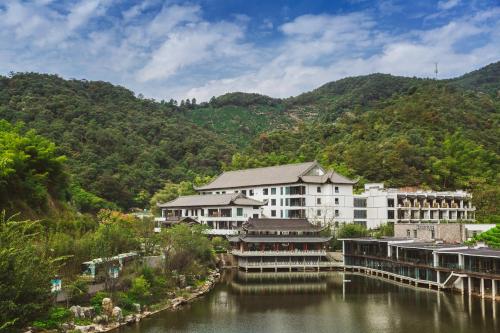 un edificio accanto a un fiume con una montagna di Hentique Resort Anji ad Anji