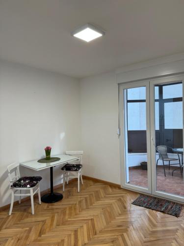 una stanza bianca con tavolo e sedie e una sala da pranzo di Apartman PARK a Trebinje