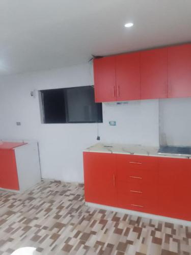 a kitchen with red cabinets and a tile floor at Mi casa in Ayacucho