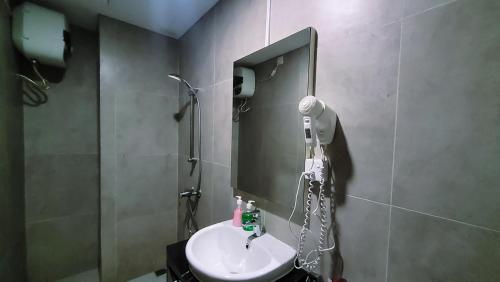 a bathroom with a sink and a mirror at Palam Mansion at Meisterstadt Pollux Habibie Apartment in Batam Center