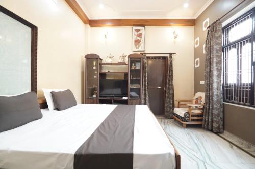 ein Schlafzimmer mit einem großen Bett und einem TV in der Unterkunft hotel banaras darbar in Kakarmatha