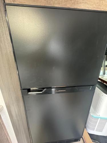 una nevera congelador negra dentro de una cocina en Petite Manufactured unit with Large Queen Bed - 2 Tvs, en Hollywood