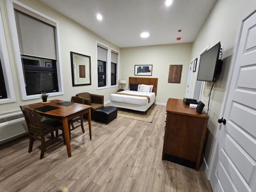 a hotel room with a bed and a table and a room at Cozy Maison Apt #4 in Gatineau