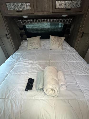 1 cama blanca grande con 2 toallas y mando a distancia en Petite Manufactured unit with Large Queen Bed - 2 Tvs, en Hollywood