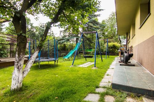 a playground with blue swings in a yard at Willa Helena in Zakopane