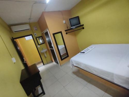 1 dormitorio con 1 cama y TV en la pared en NovHotel, en Comalcalco