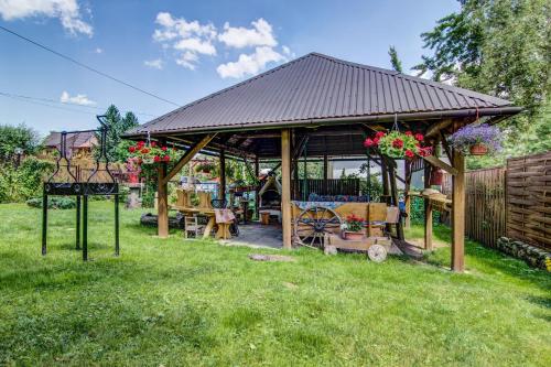 a patio area with chairs, tables, and umbrellas at Willa Helena in Zakopane