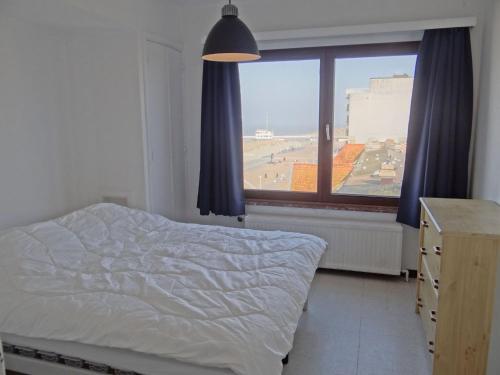 1 dormitorio con cama y ventana grande en Ibis I 601 with a view of the sea and the fairway, en Nieuwpoort