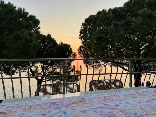 un tavolo e sedie su un balcone con vista sull'acqua di Apartment mit Meerblick am Strand Costa Azzura a Grado
