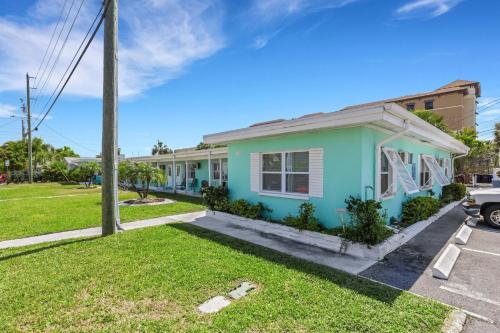 a house in a parking lot with a green at Captain's Quarters - Weekly Rental apts in Clearwater Beach