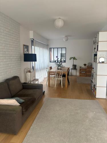 un salon avec un canapé et une table dans l'établissement Bright and spacious apartment, à Fontenay-le-Fleury