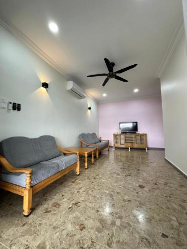ein Wohnzimmer mit Sofas und einem Flachbild-TV in der Unterkunft Penampang Delima House in Kota Kinabalu