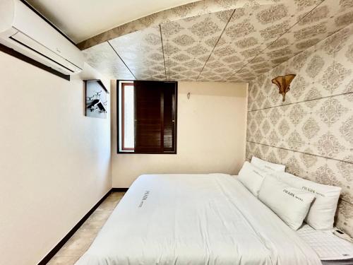 a bedroom with a large white bed in a room at Prada motel in Geoje 