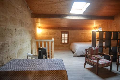 une chambre avec un lit et une chaise dans une pièce dans l'établissement Ferme de La Plante, à Saint-Aubin-de-Branne