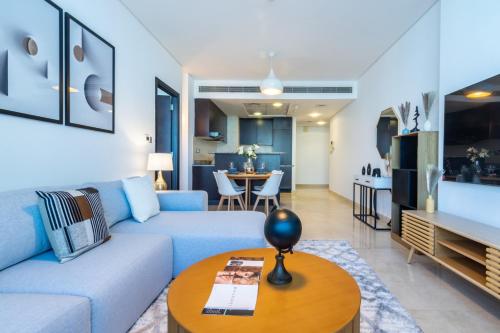 a living room with a blue couch and a table at DIFC 1BR at SkyGardens Tower in Dubai
