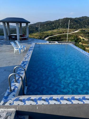 a swimming pool with two chairs and a gazebo at Hakka Villa 客家土楼 in Lengging